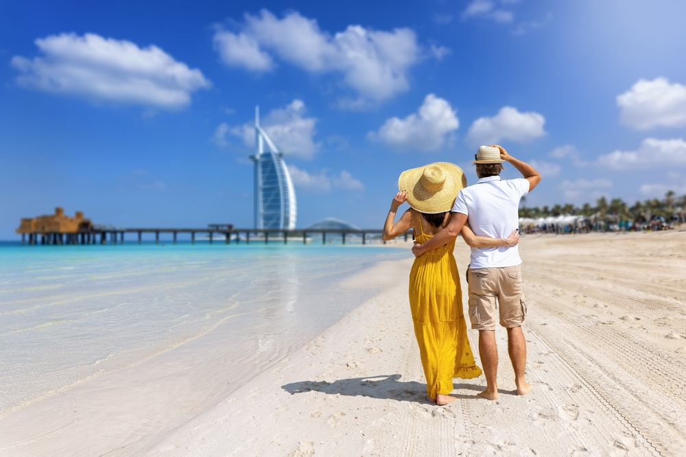 Young couple walking on the beach enjoying their relaxing holiday | Oceania Finance